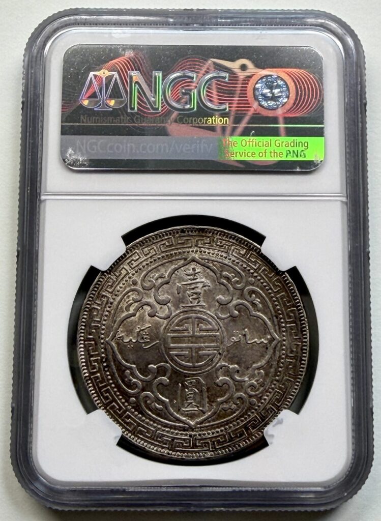 Reverse of a 1901-B Great Britain Trade Dollar certified NGC AU58, displaying Chinese characters and Jawi inscriptions within an ornate border.