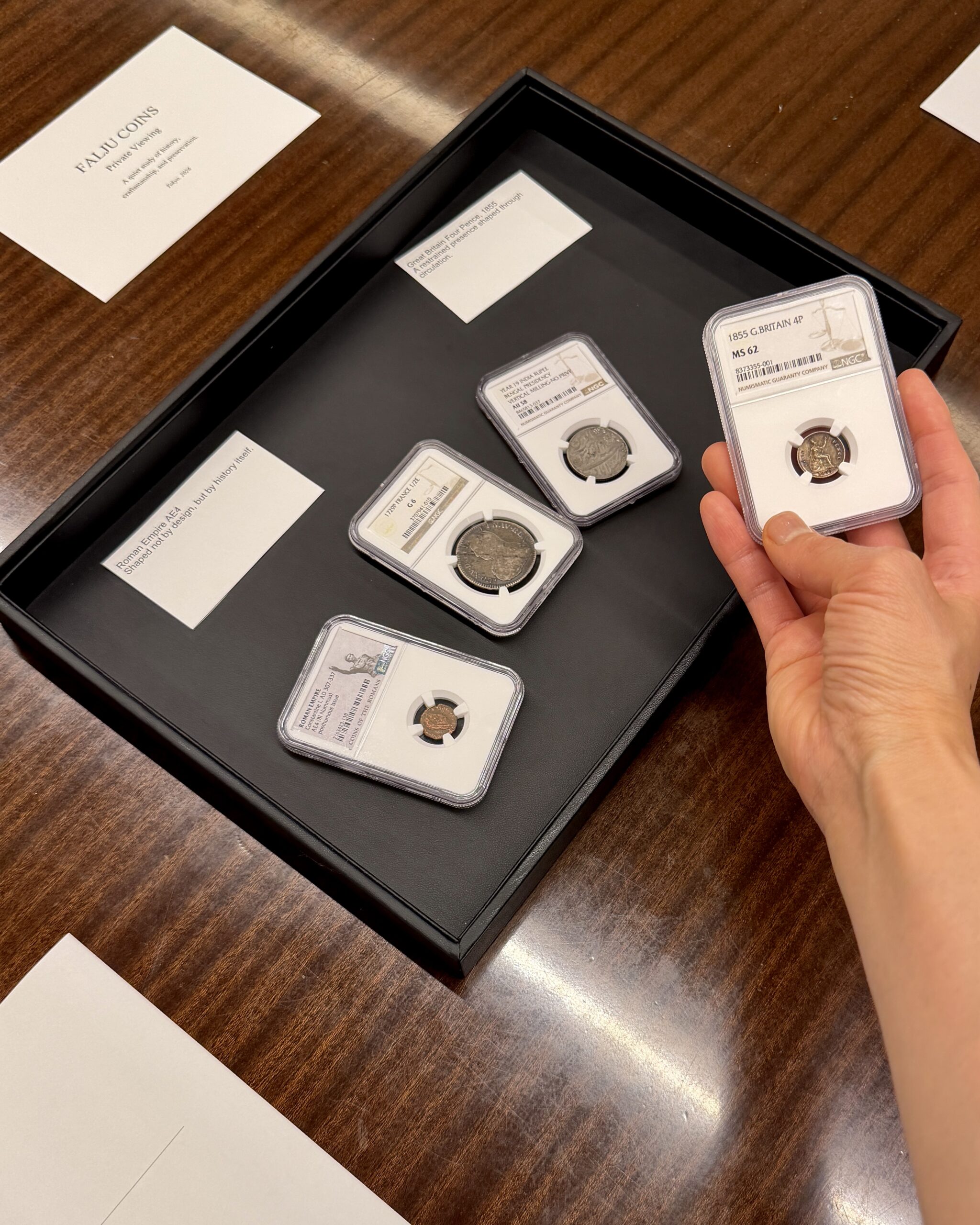 A private coin study in Tokyo featuring certified historical coins from Great Britain, France, India, and the Roman Empire, examined through history, design, and cultural context by FALJU COINS.